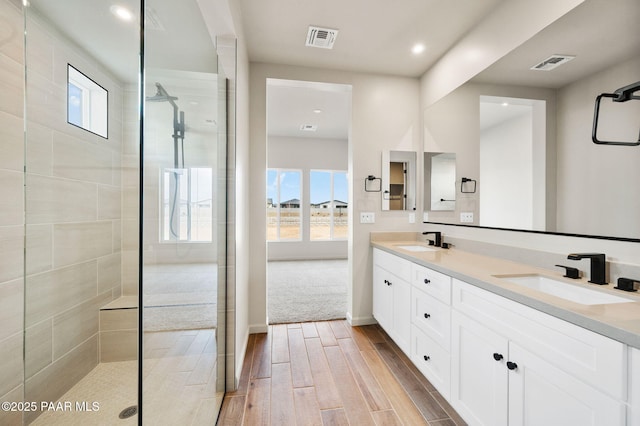 bathroom featuring wood finish floors, a sink, and visible vents