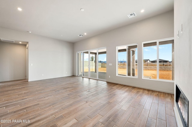 spare room with light wood finished floors, visible vents, and recessed lighting