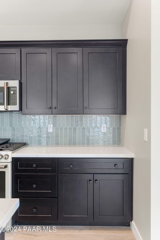 kitchen featuring backsplash and white range with gas cooktop