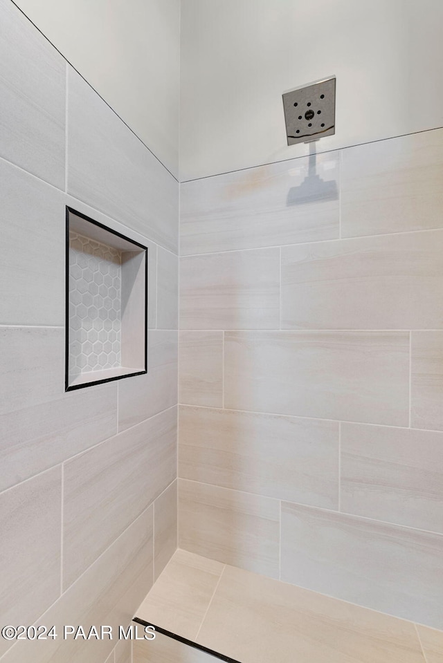 bathroom with a tile shower and tile patterned floors