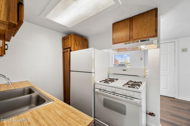 234 N Arizona Ave, Prescott, AZ 86301 - kitchen featuring white appliances, under cabinet range hood, a sink, dark wood-style flooring, and brown cabinetry
