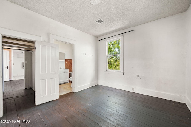 234 N Arizona Ave, Prescott, AZ 86301 - unfurnished bedroom featuring dark wood-style floors, baseboards, a textured ceiling, and connected bathroom