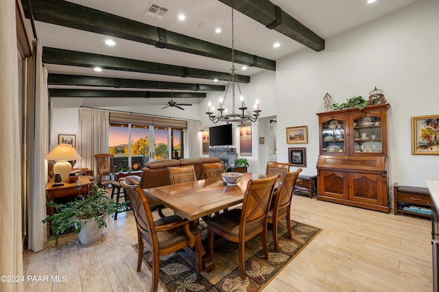 dining room with ceiling fan with notable chandelier, beam ceiling, and light hardwood / wood-style flooring