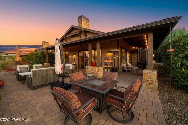 patio terrace at dusk featuring an outdoor living space