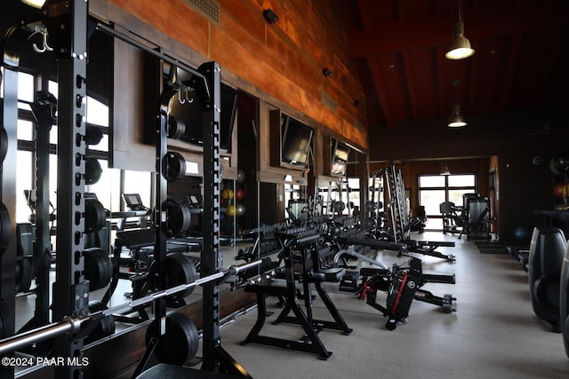 exercise room with wooden walls and lofted ceiling