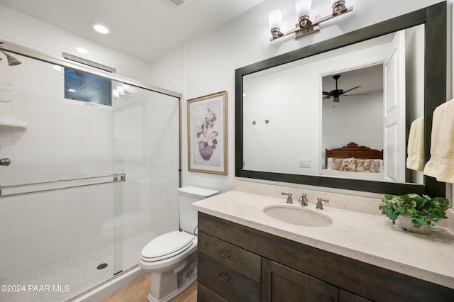 bathroom with vanity, wood-type flooring, a shower with shower door, and toilet