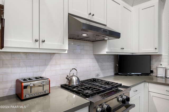 kitchen with tasteful backsplash, white cabinets, and stainless steel appliances