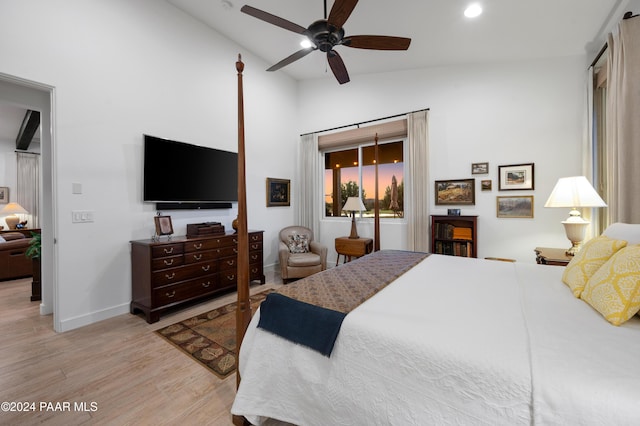 bedroom with light hardwood / wood-style flooring, vaulted ceiling, and ceiling fan