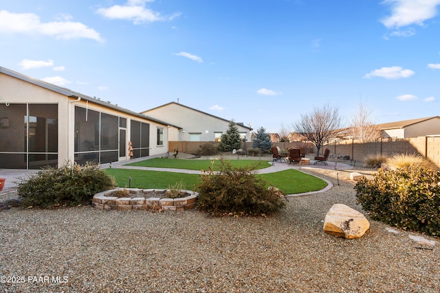 view of yard featuring an outdoor fire pit, a patio area, and a sunroom