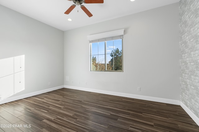 empty room with ceiling fan and dark wood-type flooring