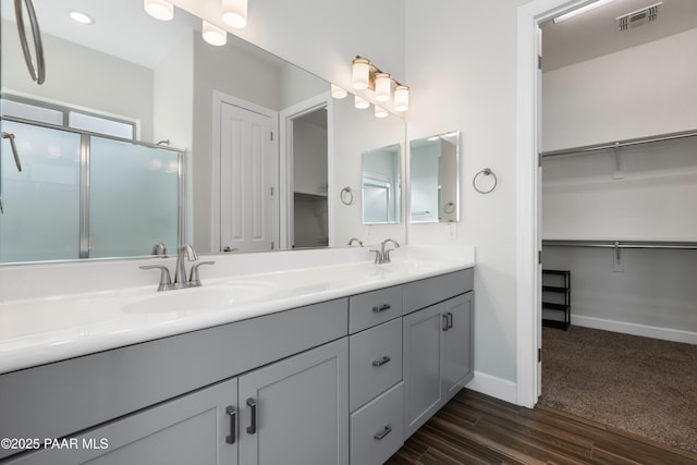 bathroom featuring vanity, walk in shower, and wood-type flooring