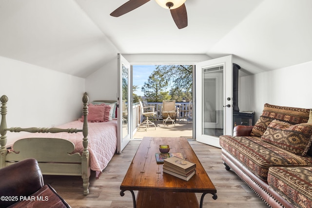 bedroom with access to outside, a ceiling fan, vaulted ceiling, and wood finished floors