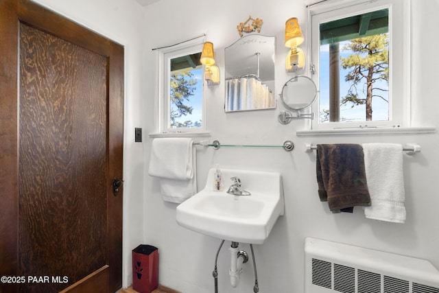 bathroom with radiator, a sink, and a healthy amount of sunlight