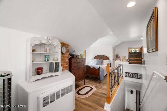 bedroom with vaulted ceiling and light wood-style floors