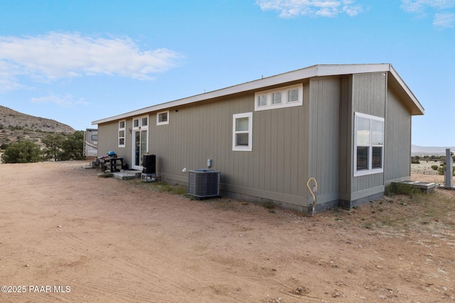 back of property with a mountain view and cooling unit