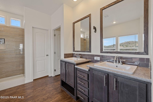 full bath with a healthy amount of sunlight, a sink, and a tile shower