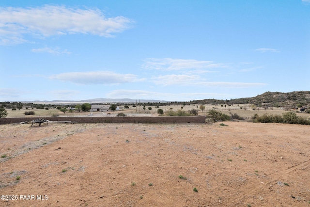 view of yard with a rural view and a mountain view