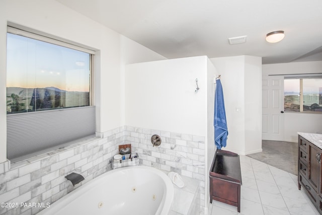 bathroom featuring vanity and a relaxing tiled tub