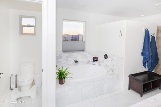 bathroom featuring toilet, tile patterned flooring, tiled bath, and a wealth of natural light