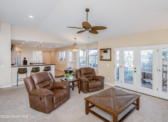 carpeted living room with lofted ceiling, sink, and ceiling fan