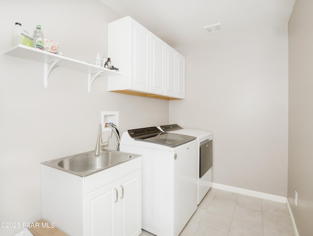 washroom featuring independent washer and dryer, sink, cabinets, and light tile patterned floors