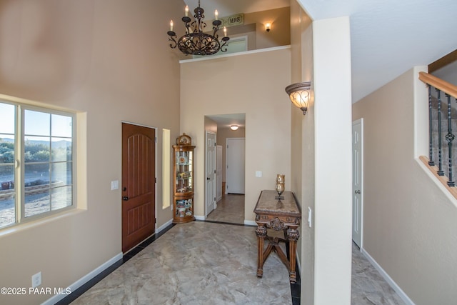 foyer featuring a towering ceiling and a notable chandelier