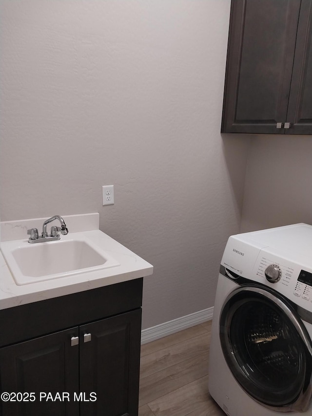 6166 E Shetland Way, Prescott Valley, AZ 86314 - washroom featuring washer / dryer, cabinet space, baseboards, and light wood-style flooring