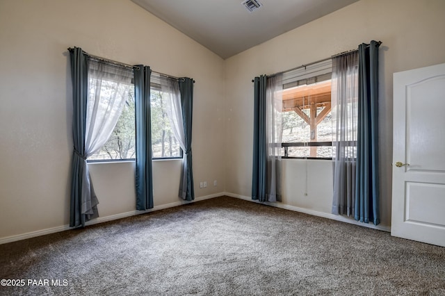 carpeted empty room featuring vaulted ceiling, visible vents, and a wealth of natural light