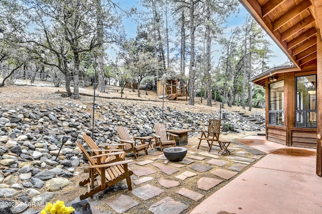 view of patio featuring playground community and an outdoor fire pit