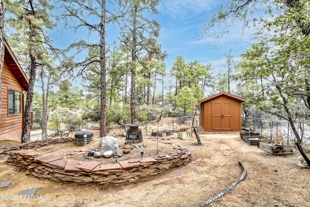 view of yard with an outbuilding, a vegetable garden, fence, and a shed