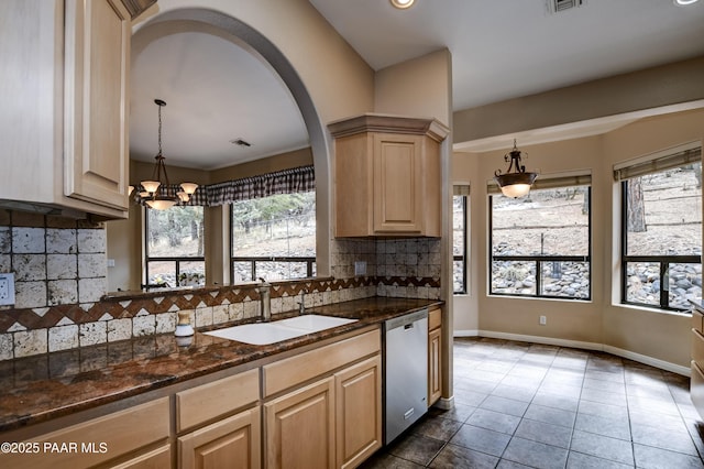 kitchen with dark tile patterned flooring, light brown cabinetry, a sink, pendant lighting, and stainless steel dishwasher