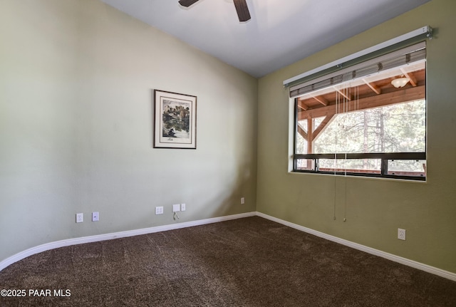 spare room with vaulted ceiling, baseboards, dark colored carpet, and ceiling fan