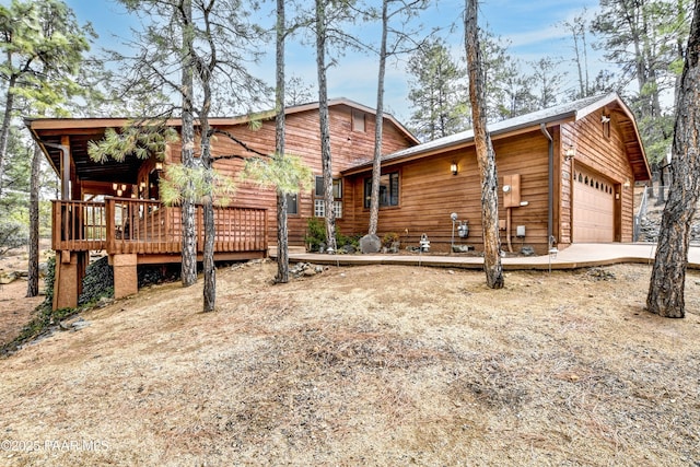 exterior space with an attached garage and a wooden deck