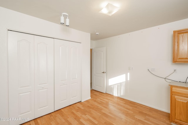 unfurnished bedroom with a closet and light hardwood / wood-style flooring