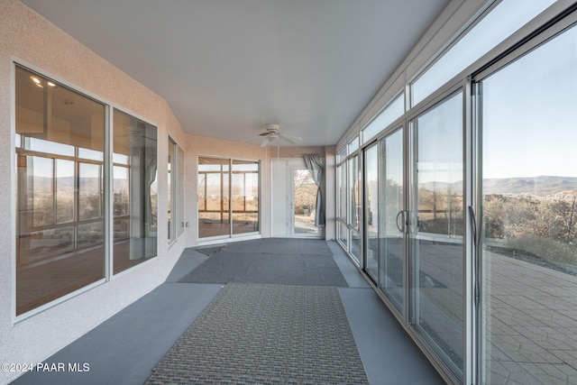 sunroom / solarium with ceiling fan and a mountain view