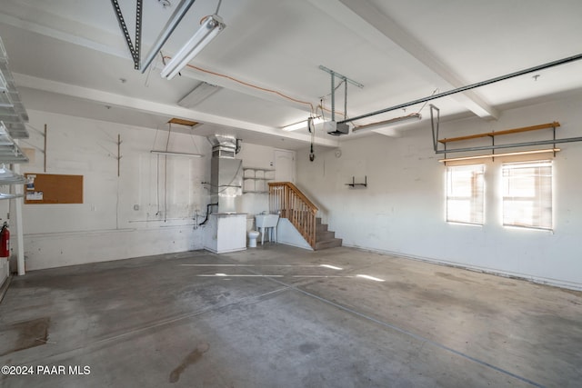 garage featuring heating unit, a garage door opener, and sink