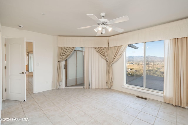 spare room featuring a mountain view and ceiling fan