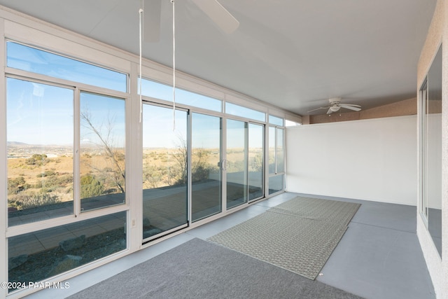 unfurnished sunroom featuring ceiling fan