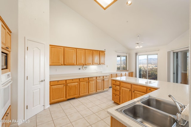 kitchen featuring high vaulted ceiling, white oven, sink, ceiling fan, and light tile patterned floors