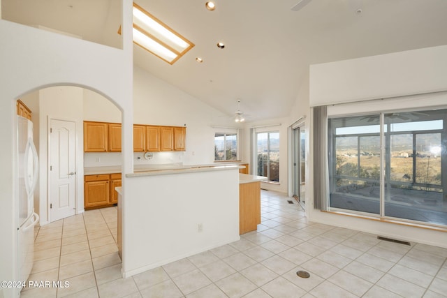 kitchen with white fridge, ceiling fan, high vaulted ceiling, and light tile patterned flooring