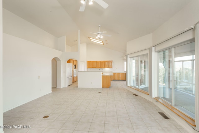 unfurnished living room featuring ceiling fan, light tile patterned flooring, and high vaulted ceiling