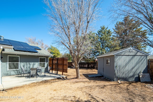 view of yard with a storage unit, a patio, an outdoor structure, and a fenced backyard