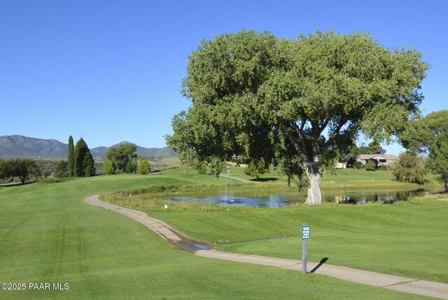 view of community featuring a lawn and a water and mountain view