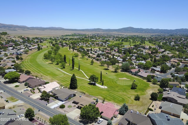 drone / aerial view with golf course view, a mountain view, and a residential view