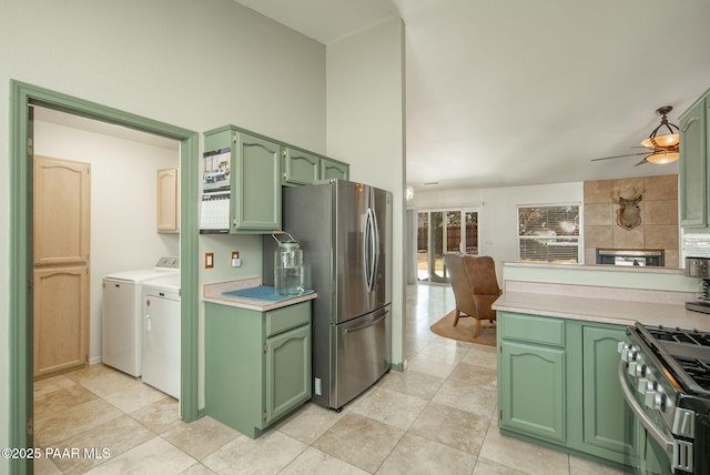 kitchen featuring washer and dryer, stainless steel appliances, green cabinets, and light countertops