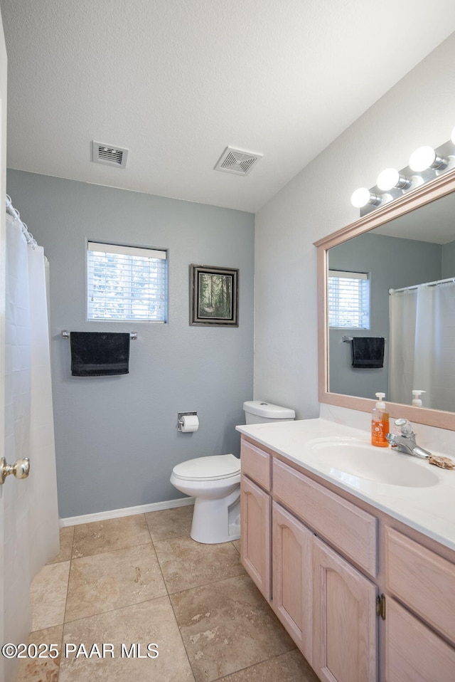 full bathroom with visible vents, a healthy amount of sunlight, and vanity