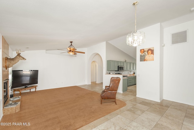 living room with arched walkways, visible vents, ceiling fan with notable chandelier, and vaulted ceiling