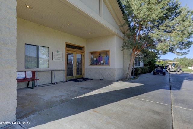 entrance to property featuring french doors and stucco siding