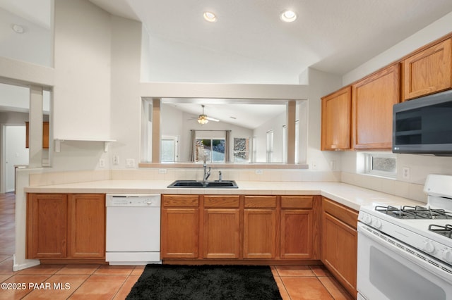 kitchen with lofted ceiling, sink, white appliances, and plenty of natural light