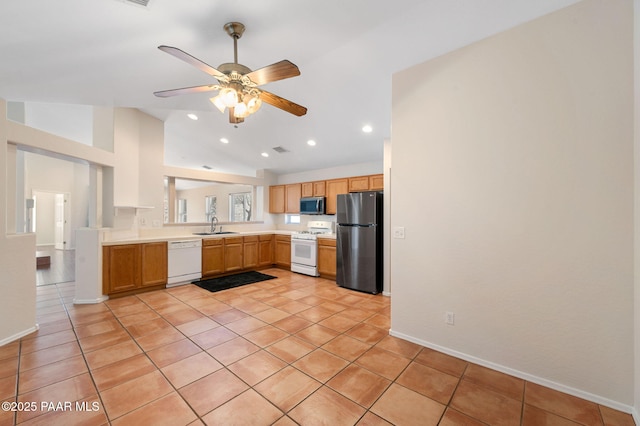 kitchen featuring vaulted ceiling, sink, light tile patterned floors, ceiling fan, and white appliances